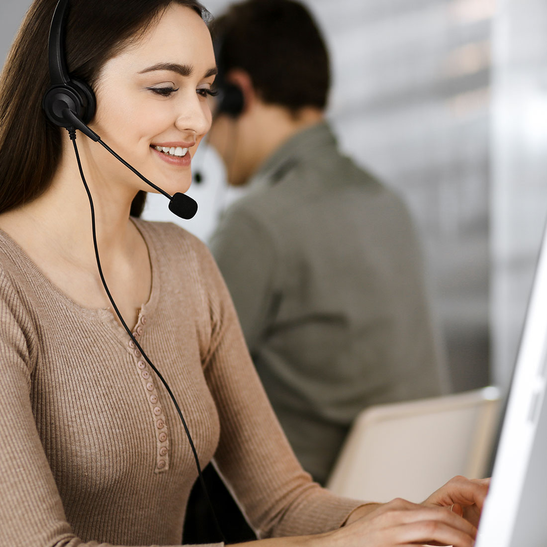 technical support representative with headset using a computer